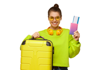 Portrait of young happy girl in neon green sweatshirt and glasses, holding travel suitcase and passport with airplane tickets in hands