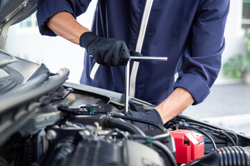 Obraz premium Professional mechanic working on the engine , repairing a car engine automotive workshop with a wrench, car service and maintenance,Repair service.
