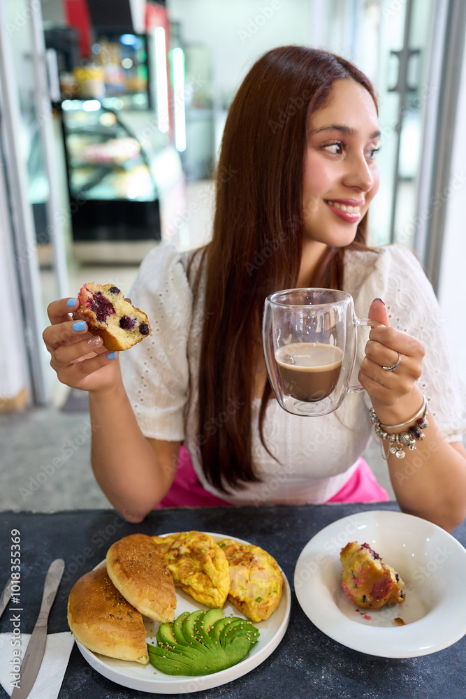 Wall mural young latin woman sitting in a cafe having healthy breakfast happy