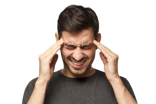 Headache concept. Young man showing how much his head hurts, experiencing pain