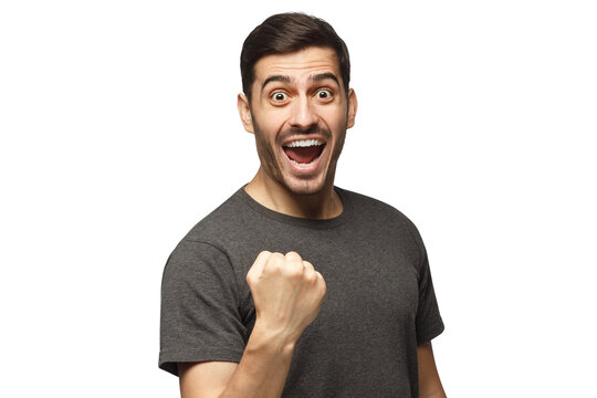 Young excited man celebrating win of his team, raised fist in victory gesture