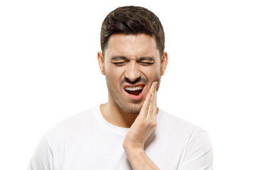 Young man with closed eyes suffering from severe toothache, touching jaw with fingers trying to ease strong tooth pain