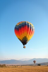 Obraz premium Colorful Hot Air Balloons Soaring Above a Serene Landscape at Sunrise