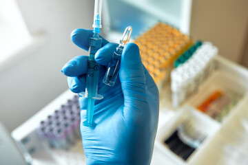 A Healthcare Professional is meticulously preparing a vaccine using a syringe and a vial