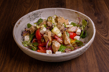 Insalata di pollo con feta greca, zucchine, pomodori e songino servita in una braceria elegante 