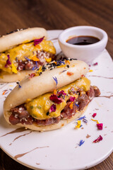 Bao ban cotti al vapore, ripieni di tartare di manzo e senape e serviti con salsa bbq in una braceria
