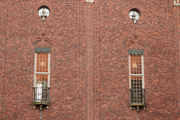 Two tall, narrow windows set into a brick wall, adding character and symmetry to the architectural...