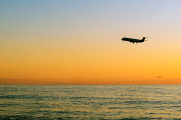 plane landing over sea at sunset. Black sea, Batumi, Georgia