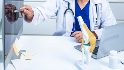Professional Health Care doctor Consultation for Patients discussing a model of a knee joint for...