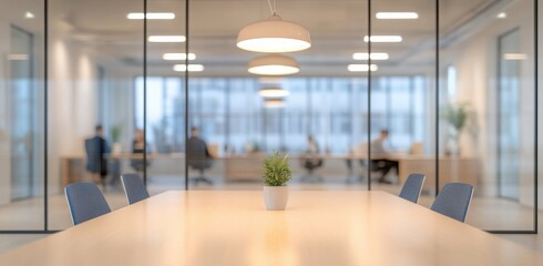 Blurred office interior with people working in the background, a business meeting concept. The glass wall of a modern open space for a casual company or co-working area. 