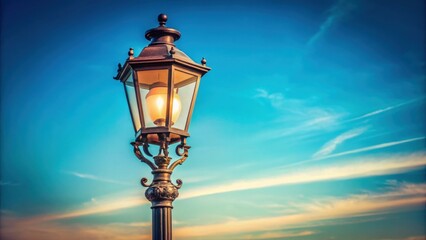 Obraz premium Vintage street lamp shining against a soft blue sky, vintage, street lamp, retro, lantern, light, antique