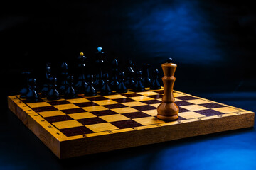 Wooden chess pieces on the chessboard. Intellectual game -chess. Chess pieces on the Board. A game of chess. One against all.