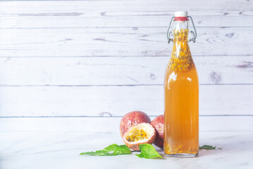 Kombucha second fermentation with passion fruit flavor in swing top bottles on white table background.