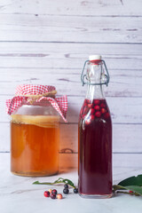 kombucha second fermentation with Buni fruit flavor in swing top bottles on white table background.
