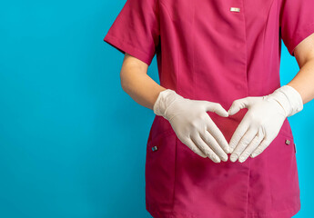 Dentista irreconocible con las manos en forma de corazón, en fondo azul con espacio para texto.