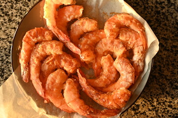 baked shrimps without shells in aero grill, tasty healthy food concept, baked seafood in breading, European cuisine, fried cooked shrimp tails fried in clary close-up 