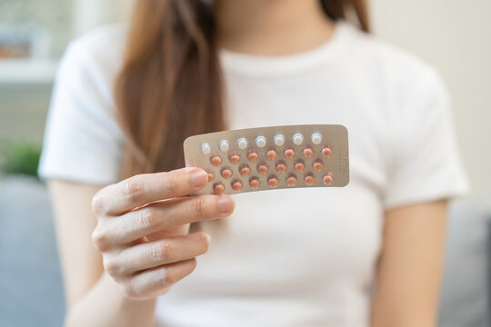 Contraception and pregnancy, menstruation concept, birth control pills asian young woman hand holding hormonal oral contraceptive medicine, take pharmaceutical to prevention, safe virus sex disease.