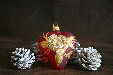 Happy New Year. Mouth blown and hand painted glass heart with pinewood cone in snow. Christmas decor. 