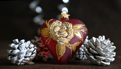 Happy New Year. Mouth blown and hand painted glass heart with pinewood cone in snow. Christmas decor. 