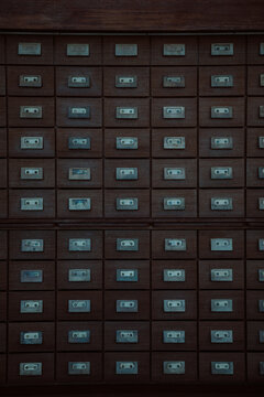 A large wooden cabinet filled with numerous small drawers is prominently featured. Each drawer has a metallic label holder, giving the piece an organized and vintage appearance.