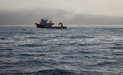 Fishing boat. A boat sails through the Atlantic Ocean, near the coast of Galicia on a foggy day. © Ricardo