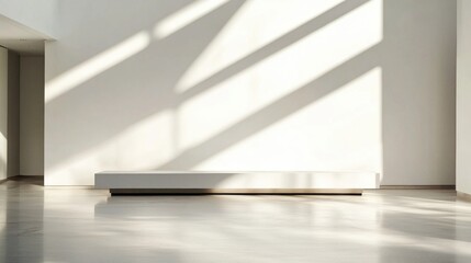 Bright natural light streams through a large window, creating long shadows that enhance the simplicity of the design. The space features a sleek white bench against a pristine wall