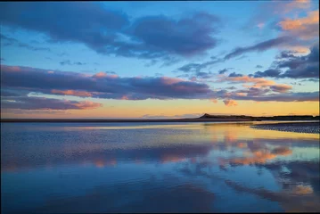 Sunset over Montrose Beach with its Sand Dunes in the background taken from St Cyrus Beach at a low winter tide.