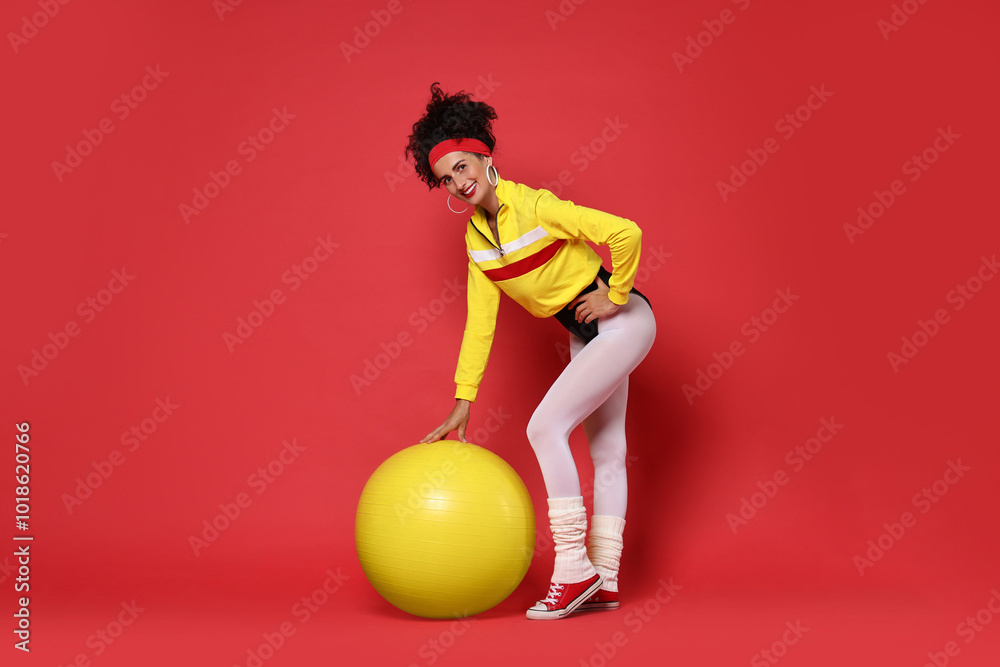 Wall mural Aerobics. Happy woman with fitness ball on red background