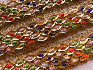 lace design features golden leaves intricately adorned with a vibrant mix of white, orange, blue,...