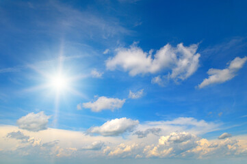 Blue sky with white clouds and sun.