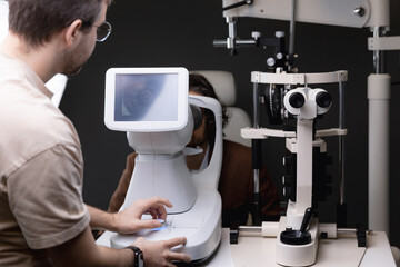 Ophthalmology clinic, Doctor ophthalmologist checks vision of adult man. Eyesight test with optometry machine for new glasses