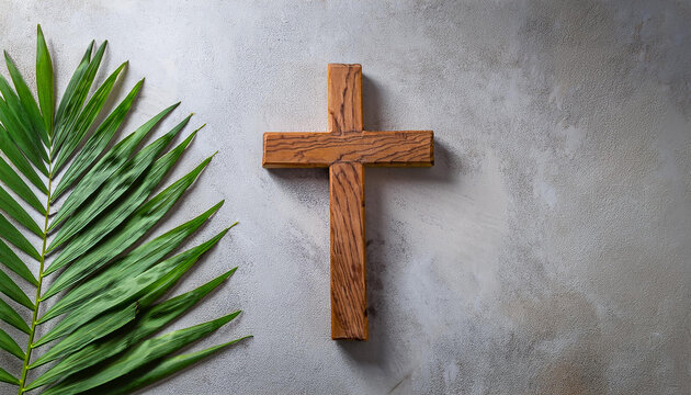 Wooden Cross and green palm leaf on cement background. Religion and Christian fait concept.