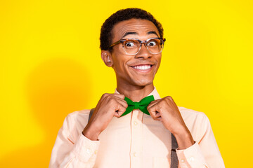 Photo of elegant young man toothy smile fix bow tie wear shirt isolated on yellow color background