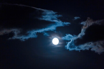 Obraz premium full moon in the night sky among the clouds.