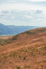 Majestic mountains under a blue sky filled with clouds, showcasing natural beauty and rugged terrain