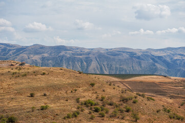 Majestic mountains under a blue sky filled with clouds, showcasing natural beauty and rugged terrain