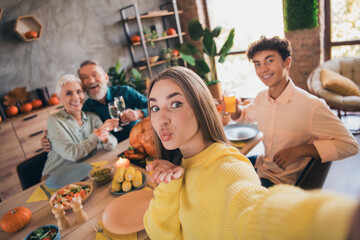 Photo of four friendly family members make selfie eat drink send air kiss you celebrate thanksgiving dinner apartment indoors