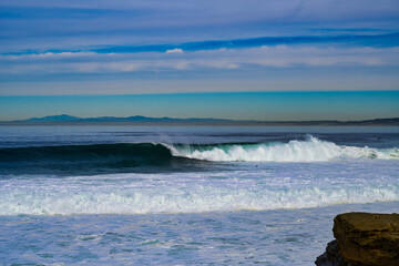 2023-12-31 WAVES CRESTING ALONG THE LA JOLLA COASTLINE WITH A NICE CALM SKY NEAR SAN DIEGO CALIFORNIA