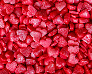 Background of little red and pink hearts.Close-up mini hearts candy.Varied sugar sprinkles, stars, flowers,hearts, dots.Toppings for desserts and ice cream.