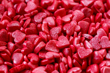 Background of little red and pink hearts.Close-up mini hearts candy.Varied sugar sprinkles, stars, flowers,hearts, dots.Toppings for desserts and ice cream.