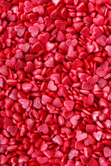 Background of little red and pink hearts.Close-up mini hearts candy.Varied sugar sprinkles, stars, flowers,hearts, dots.Toppings for desserts and ice cream.