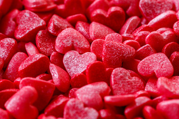 Background of little red and pink hearts.Close-up mini hearts candy.Varied sugar sprinkles, stars, flowers,hearts, dots.Toppings for desserts and ice cream.