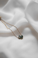 gold necklace on a satin background