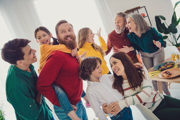 Photo of attractive cheerful big full family play together meeting eating holiday dinner good mood having fun at home indoors