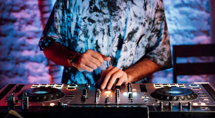 Manos de un dj tocando un mixer