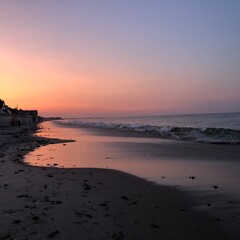 Serene New England Beach Sunset with Gentle Waves and Reflections