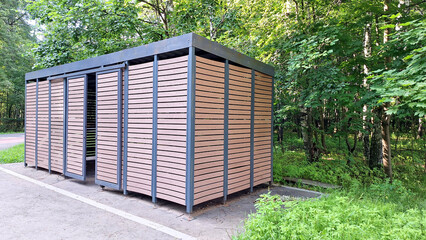 Modern wooden outdoor restroom amidst forest setting