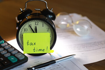 Retro Alarm Clock with Tax Documents, Calculator, and Sand Timer - Tax Time Concept