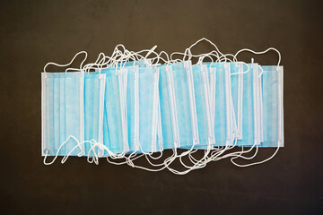 Stack of Blue Face Masks on Dark Background - Health Protection and Safety Concept