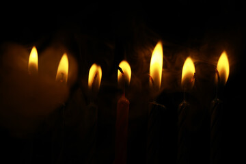 Dimly Lit Candles with Warm Flickering Flames in a Dark Ambiance